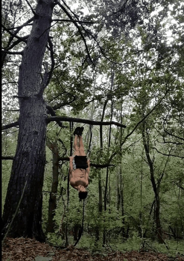 Homme faisant une figure de streetworkout dans la forêt, une bonne alternative au parc de streetworkout