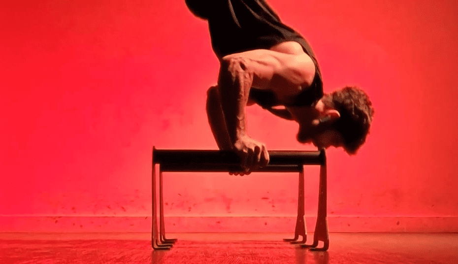 Athlète réalisant un handstand push up sur parallette