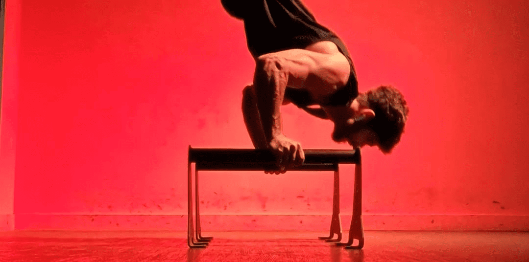 Athlète réalisant un handstand push up sur parallette